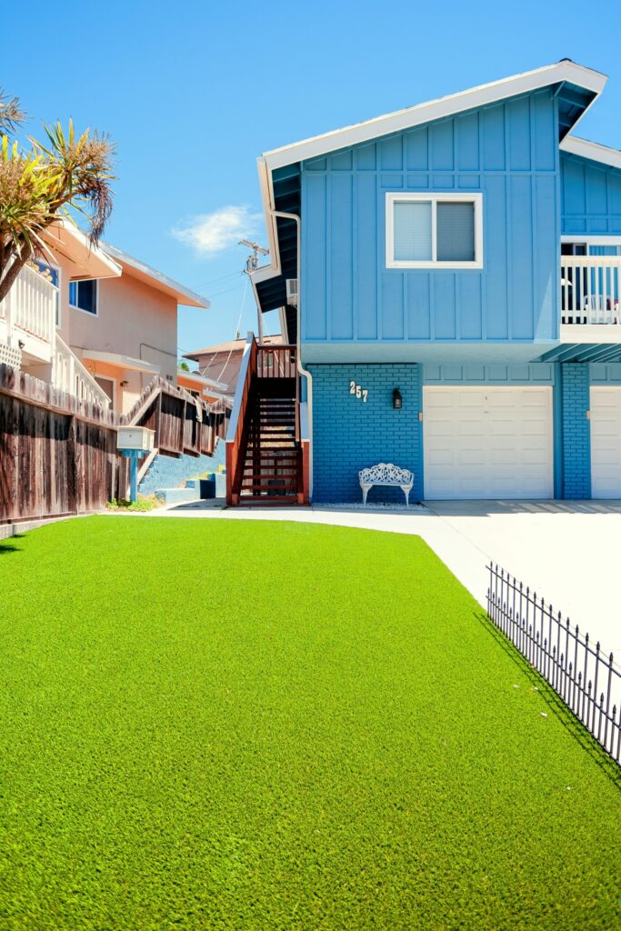 jardin cesped artificial con casa azul